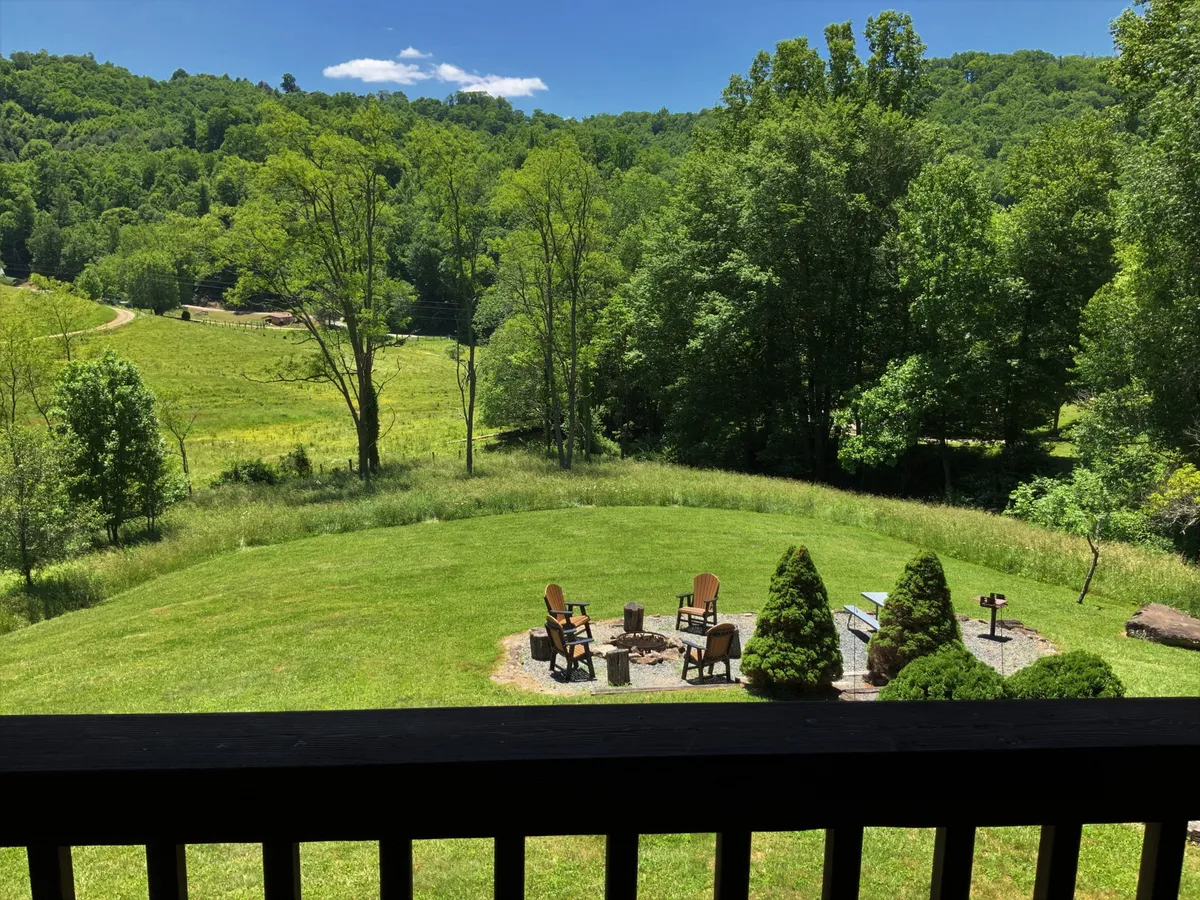 The image showcases a peaceful fire pit area surrounded by Adirondack chairs and lush greenery. The setting is perfect for unwinding after a day of adventure, and the open space suggests a pet-friendly environment where dogs can be nearby as guests enjoy the outdoors. The natural surroundings reinforce the theme of adventure and connection to nature.